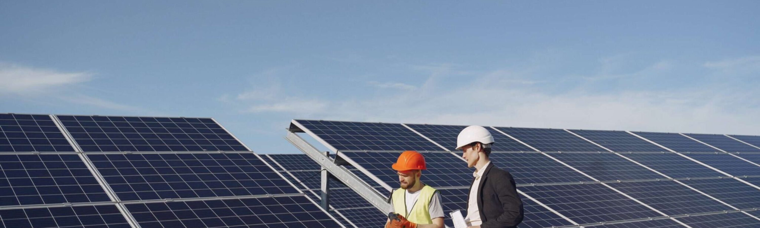 Businessman and worker near solar energy batteries. Business client showing photovoltaic detail to foreman. Two men making deal.