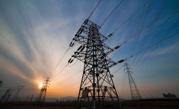 High voltage electricity pylon over sunset.